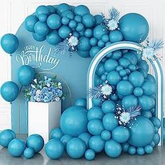 blue balloons and flowers are in front of a birthday backdrop