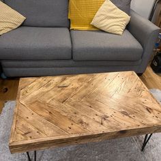 a living room with a gray couch and wooden coffee table in front of a grey sofa