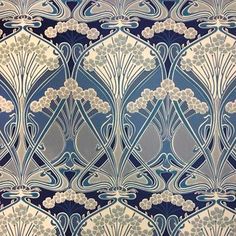 a blue and white wallpaper with an intricate design on it's side,