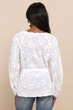 Get ready to fall in love with the charming vibes of the Lulus Wonderfully Darling White Embroidered Drawstring Tie-Front Top! Airy woven cotton, with floral embroidery and 3D floral accents throughout, shapes long raglan balloon sleeves (with elastic at the cuffs). Crew neckline features an adjustable drawstring, atop a blousy bodice with a tie detail and a matching drawstring tie at the waist. Hidden hook-and-eye closures at front. Fit: This garment fits true to size. Length: Size medium measu Feminine Cotton Embroidered Top, Feminine Cotton Embroidered Top For Daywear, White Long Sleeve Blouse With Floral Applique, Feminine Cotton Embroidered V-neck Top, Cotton Embroidered Long Sleeve Top With Lace Trim, Feminine Cotton Blouse With Floral Embroidery, Lace Tops With Floral Embroidery For Brunch, Spring Cotton Embroidered Top With Chikankari, Feminine Spring Tops With Chikankari Embroidery