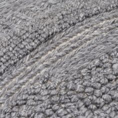 the texture of an upholstered blanket is shown in grey and white colors,