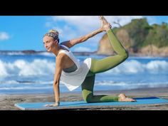 a woman is doing yoga on the beach