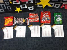 some candy bags are lined up on the floor next to other snacks and candies