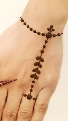 a woman's hand with a tattoo on it and a pen in the middle