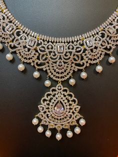 Indulge in luxury with our exquisite South Indian Haaram necklace. Adorned with CZ American Diamonds, it is the perfect accessory for weddings, parties, and gifting. Elevate your Indian outfit, be it a silk saree or gown, with this long and elegant necklace. A must-have for every sophisticated and exclusive wardrobe. This jewellery set includes a necklace and matching earrings. Jewellery Care- Keep the jewellery dry, avoid contact with perfumes and water. Elegant Lehenga With Intricate Design For Diwali, Elegant Heavy Lehenga For Diwali, Elegant Heavy Lehenga For Festive Occasions, Elegant Festive Heavy Lehenga, Elegant Party Lehenga With Tilla Detailing, Elegant Party Lehenga With Tilla Work, Luxury Kundan Bridal Necklace For Party, Luxury Stone Work Bridal Necklace For Reception, Luxury Bridal Necklace With Stone Work For Reception