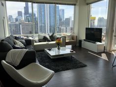 a living room filled with furniture and large windows