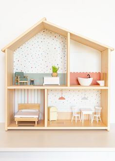 a doll house with furniture and accessories on the top shelf in front of a white wall