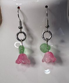 These handmade flower earrings feature Czech glass beads and glass leaf beads. Pink flower with a white seed bead and a light green leaf. They measure about an inch and a half long from the bend in the hook. Green Flower Drop Earrings With Dangling Beads, Green Dangle Flower Earrings With Beads, Green Dangle Earrings With Dangling Beads, Green Flower Earrings With Round Beads, Pink Flower Dangle Earrings With Beads, Green Flower Earrings With Dangling Beads, Pink Dangling Beads Flower Drop Earrings, Beaded Flower Earrings In Czech Glass, Green Dangling Bead Flower Earrings