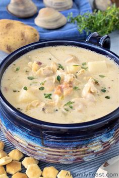 a close up of a bowl of soup on a table with potatoes and parsley