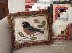 a bird pillow sitting on top of a couch next to a wall hanging with pictures