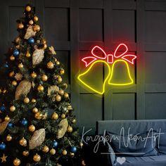 a christmas tree with two bells on it next to a neon sign that says merry