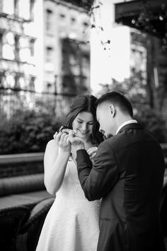 a bride and groom standing together in front of a building