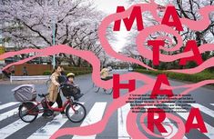 a woman riding a bike across a crosswalk next to a child in a stroller