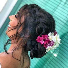 a woman with flowers in her hair next to a pool