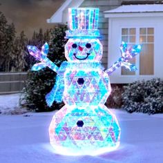 a lighted snowman in front of a house