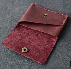 a red wallet sitting on top of a gray floor