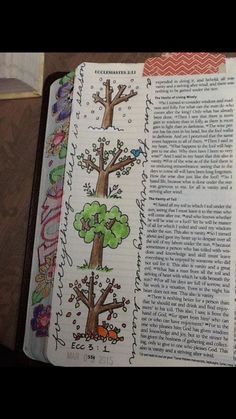 an open bible with pictures of trees on it