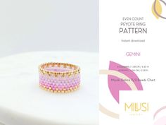 a pink and gold beaded ring sitting on top of a white table next to an advertisement