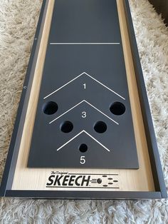 a black shuffle board sitting on top of a white shaggy rug with numbers and arrows