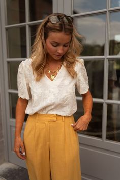 Say hello to your new wardrobe essential! This white blouse features a playful V-neck and a cute bow detail in the back. Delicate embroidered florals add an elegant touch to its subtly sheer fabric. Our models are also wearing the Joey pants, Maddie jeans, and the Sole necklace Sizes: S / M / L S: Length 21.26 in - Width 18.50 in M: Length 21.65 in - Width 19.29 in L: Length 22.05 in - Width 20.08 in 100% cotton Washing: handwash only Feminine Floral Embroidery Blouse For Workwear, Floral Embroidered Summer Workwear Blouse, Chic Floral Embroidery Tops For Work, Summer Workwear Blouse With Floral Embroidery, Chic Daywear Blouse With Floral Embroidery, Chic Blouse With Floral Embroidery For Daywear, Casual Workwear Blouse With Floral Embroidery, Floral Embroidery V-neck Top For Work, Summer Floral Embroidery Workwear Blouse