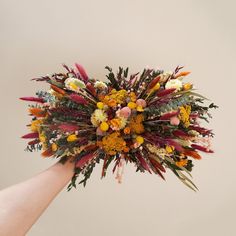 a bouquet of flowers is being held by someone's hand