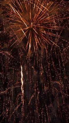 fireworks exploding in the night sky with lots of lights on it's sides and dark background