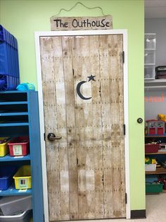 a wooden door with the word the outhouse painted on it in front of a playroom