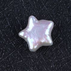 a white star shaped object sitting on top of a black surface