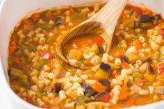 a white bowl filled with soup and a wooden spoon