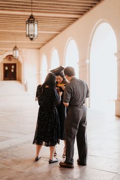 a man and woman standing next to each other in front of a building with arches