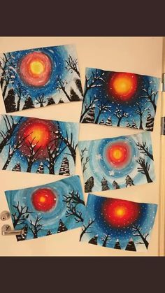 four pictures of trees with red and blue colors on them are hanging on the wall