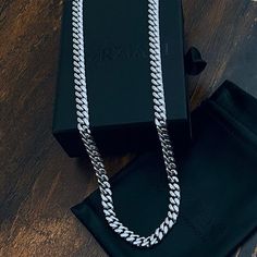 Showcase your impeccable taste, and let the Crescent Chain become your own signature accessory. Inspired by classic and original motifs, the smooth curves of polished links add a modern twist to this sleek chain, allowing for an easy, comfortable wear all day long. Crescent Link Chain Necklace Chain Width: 8mm Wide Chain Length: 26" and 30" Core Material: Stainless Steel Finish: Silver PVD Coated Clasp: Lobster Closure Classic White Gold Chunky Chain Jewelry, Classic White Gold Jewelry With Chunky Chain, Classic Silver Cuban Link Chain Necklace, Elegant Cuban Link Necklace As A Gift, White Gold Curb Chain Necklace, Luxury White Cuban Link Necklace, Silver Luxury Snake Chain Necklace, Classic Cuban Link Oval Chain Necklace, Silver Cuban Link Necklace For Everyday Elegance