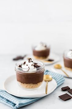 two desserts with chocolate and whipped cream on top are sitting on small white plates