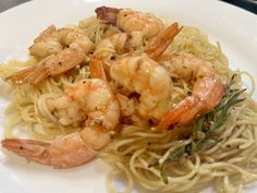 a white plate topped with pasta and shrimp