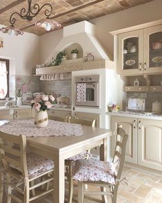 a kitchen with an oven, table and chairs