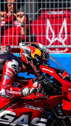 a man riding on the back of a red motorcycle