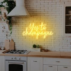 a neon sign that says yes to champagne on the side of a wall above a stove