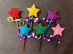 five star shaped lollipops with ribbons and bows are on a gray surface