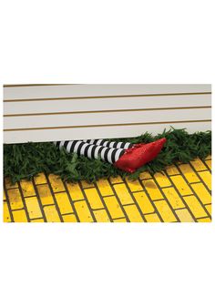 a red shoe sitting on the ground next to a yellow and black checkered tile