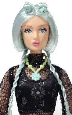 a doll with blue hair wearing a black top and green necklace on it's neck