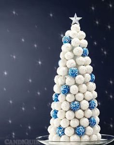 a christmas tree made out of white and blue candioulks on a glass plate