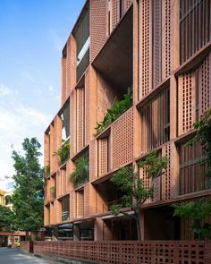 the building is made out of red bricks and has plants growing on it's sides