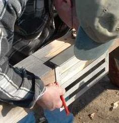 a man is sitting on a bench with a pencil in his hand and another person standing next to him