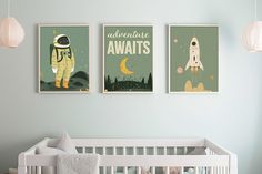 two posters on the wall above a crib in a baby's nursery room