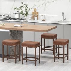 a kitchen table with four stools in front of it and a counter top on the other side