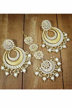 This jewellery set consists of maang tikka & earrings. This set is crafted in gold plating & features stone studded with pearl setting .Maang tikka is secured with a hook closure. Style this set with your ethnic attire to complete the look. Product Features:   Color: Gold Material: Alloy Occasion: Wedding Disclaimer: There will be slight difference in digital to actual image Pearl Setting, Pearl Earring Set, Western Clothing, Chandbali Earrings, Maang Tikka, Kundan Earrings, Indian Earrings, Back Jewelry, Pearl Earring