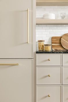 a white refrigerator freezer sitting next to a wooden cutting board on top of a counter