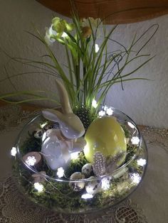 a glass bowl filled with plants and lights