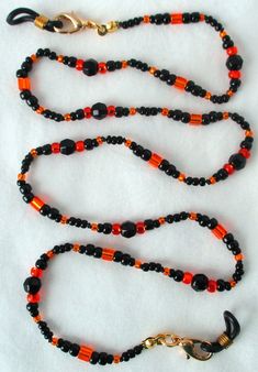 You'll never leave your glasses behind using this black & orange beaded eyeglass chain! 25" in length, made with glass beads, beading cord, metal lobster clasps, and adjustable rubber holders. Lobster clasps make it easy to change the rubber holders, and an extra pair of holders included with every purchase. This black & orange beaded eyeglass chain will arrive in a gift box, ready to give as a present or to keep and store. Back to Beaded Eyeglass Chains Black Glass Beaded Necklaces With Colorful Beads, Black Glass Beaded Necklace With Colorful Beads, Black Glass Beaded Necklaces With Beaded Chain, Black Glass Beaded Necklace With Beaded Chain, Adjustable Black Czech Glass Jewelry, Black Beaded Necklaces With Lobster Clasp, Black Glass Beaded Necklace, Handmade Glass Beads In Black, Handmade Black Glass Beads