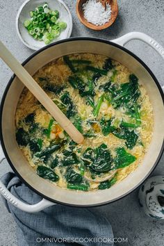 a pot filled with spinach and rice on top of a table